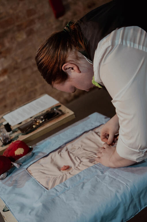 Loke, dressed in a suit, operating on a quilt of a human chest.